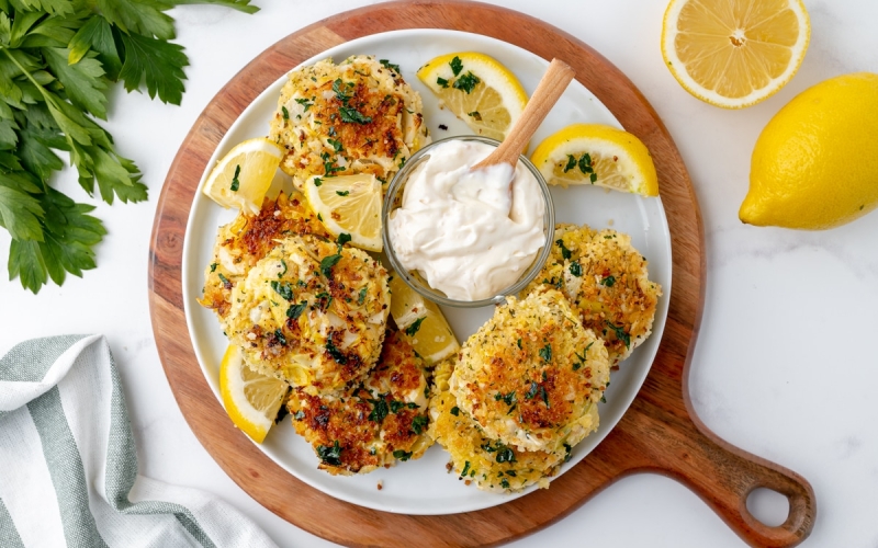 overhead shot of hearts of palm cakes on a platter with dipping sauce