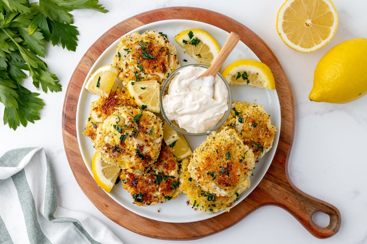 overhead shot of hearts of palm cakes on a platter with dipping sauce