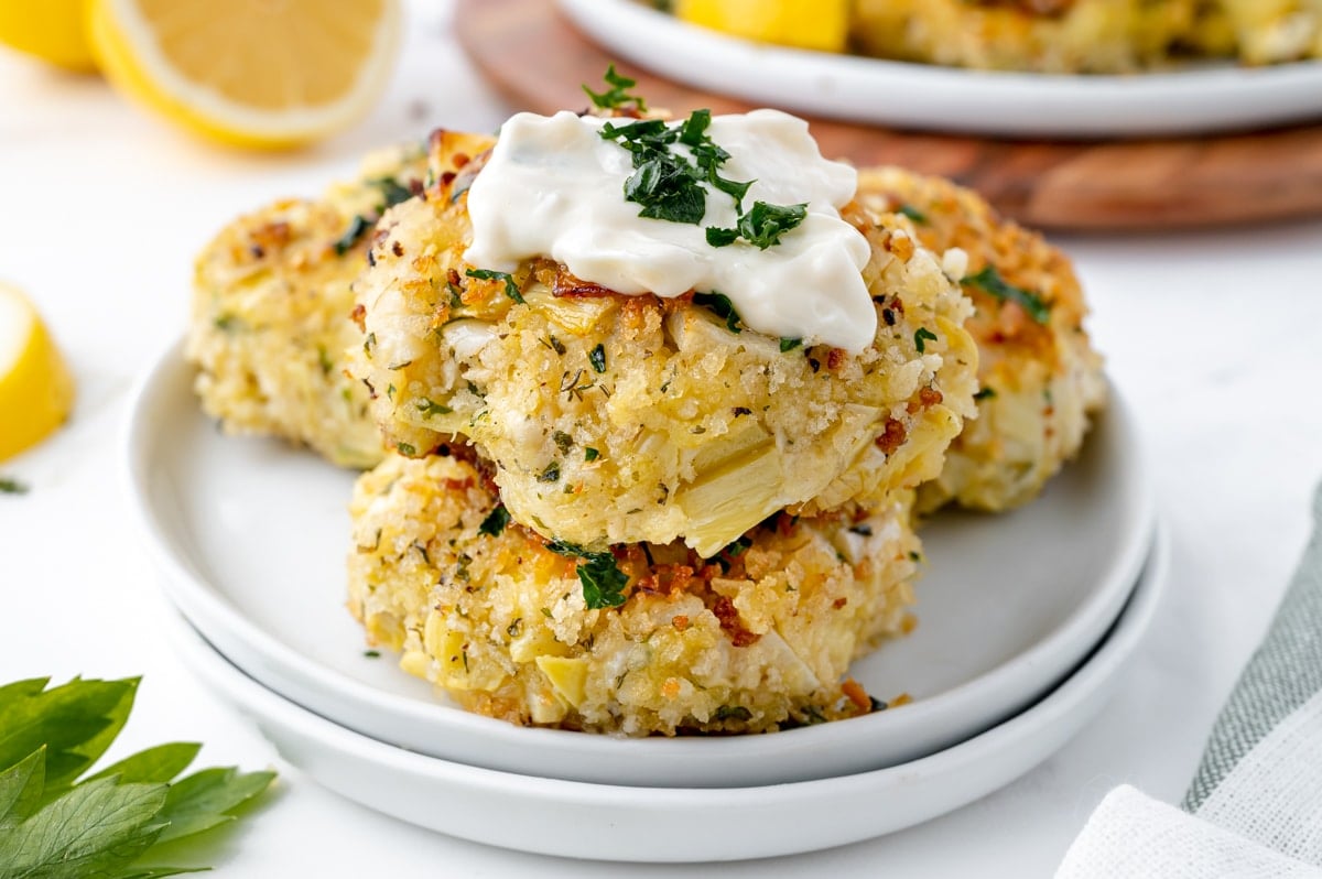 stack of heart of palm cakes topped with sauce on a plate