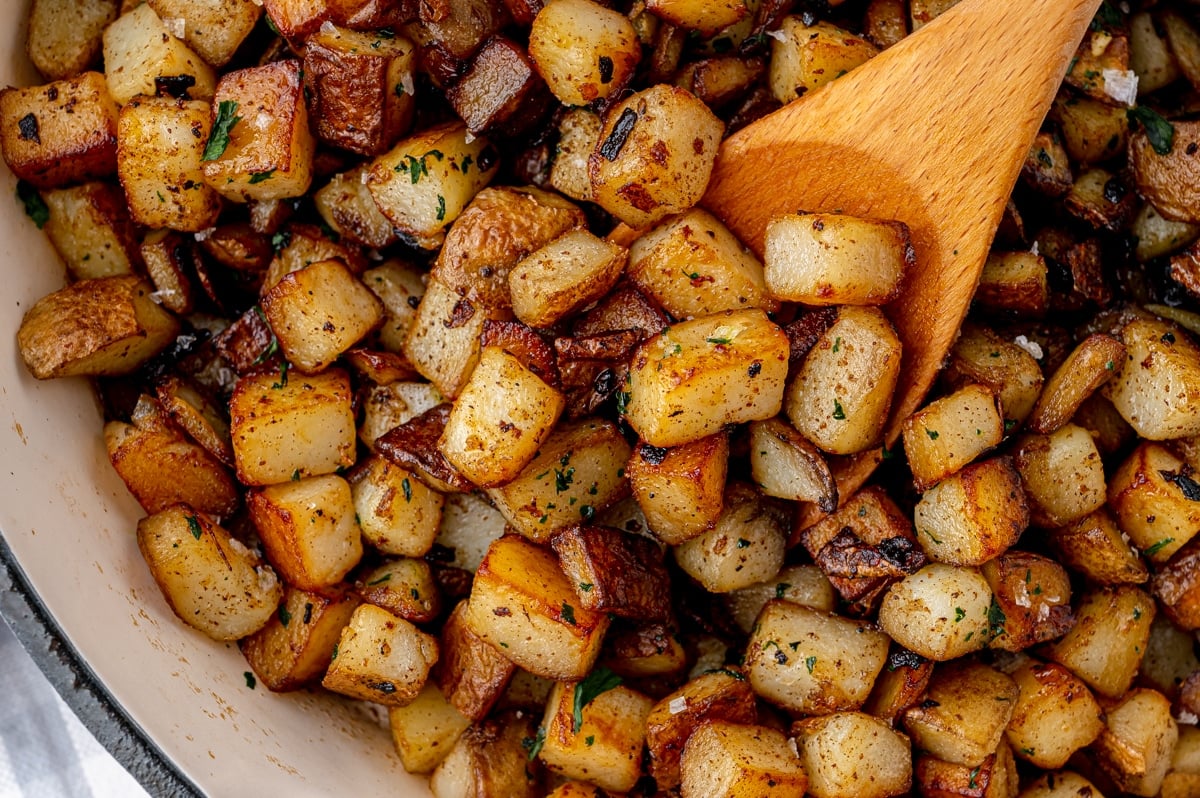 seasoned potatoes with a wooden spoon