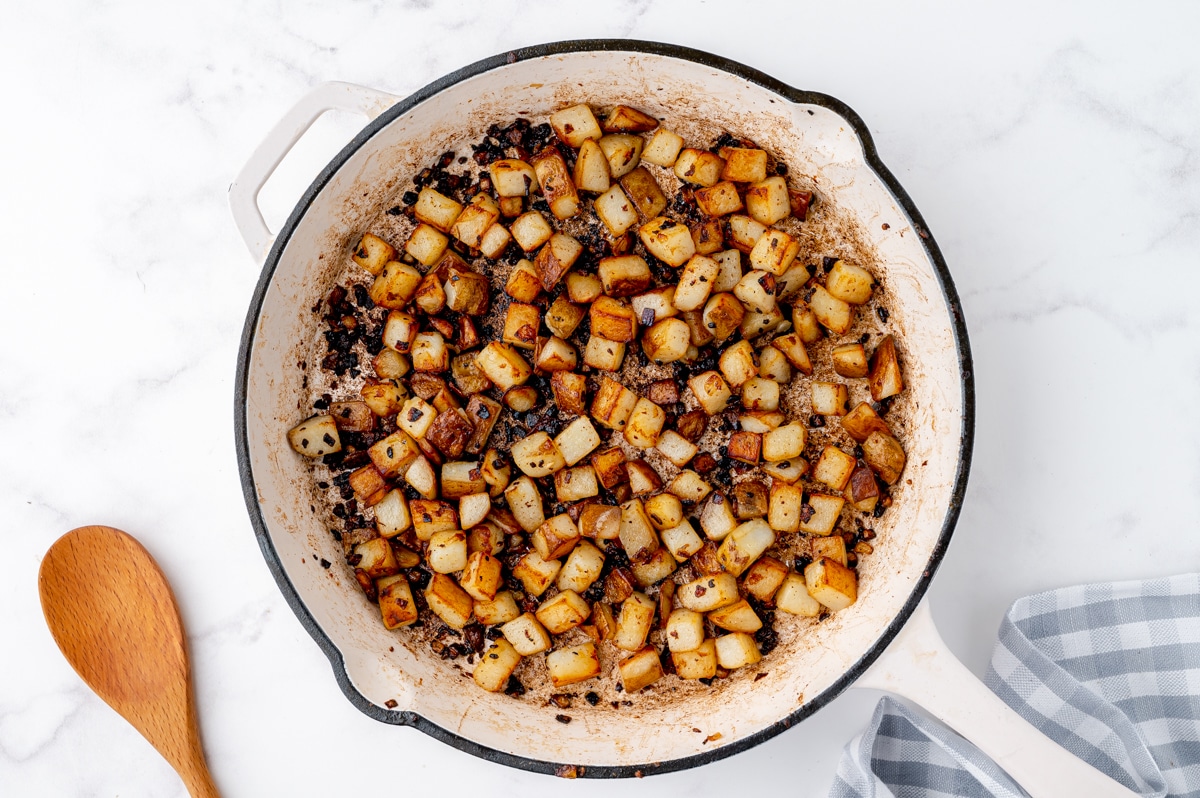 crispy browned potatoes in a white serving bowl