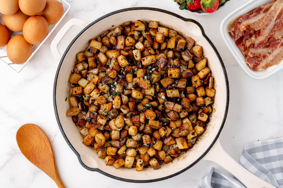 crispy home fries in a white frying pan