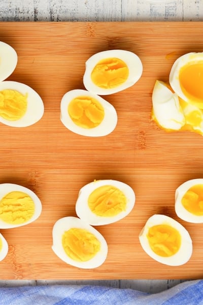 overhead of eggs cut in half on a wood cutting board