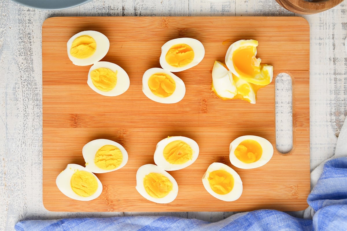 overhead of eggs cut in half on a wood cutting board