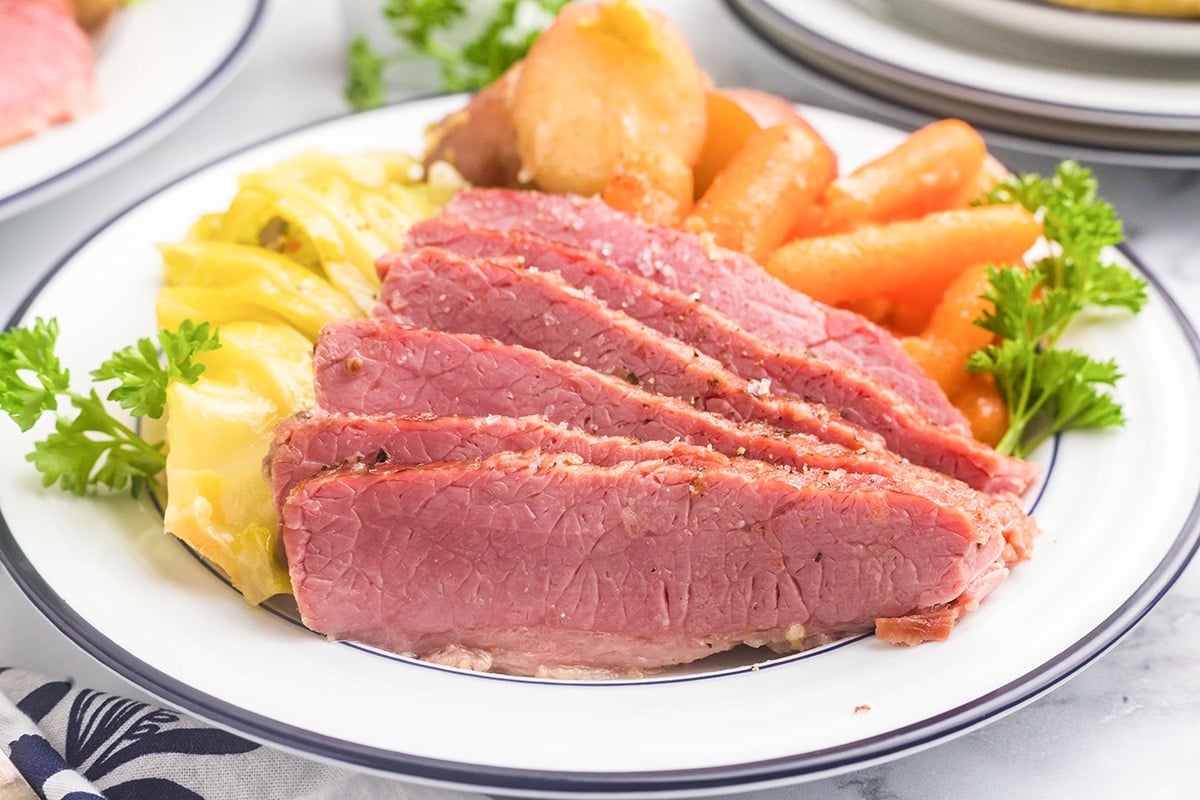 juicy sliced corned beef on a white plate