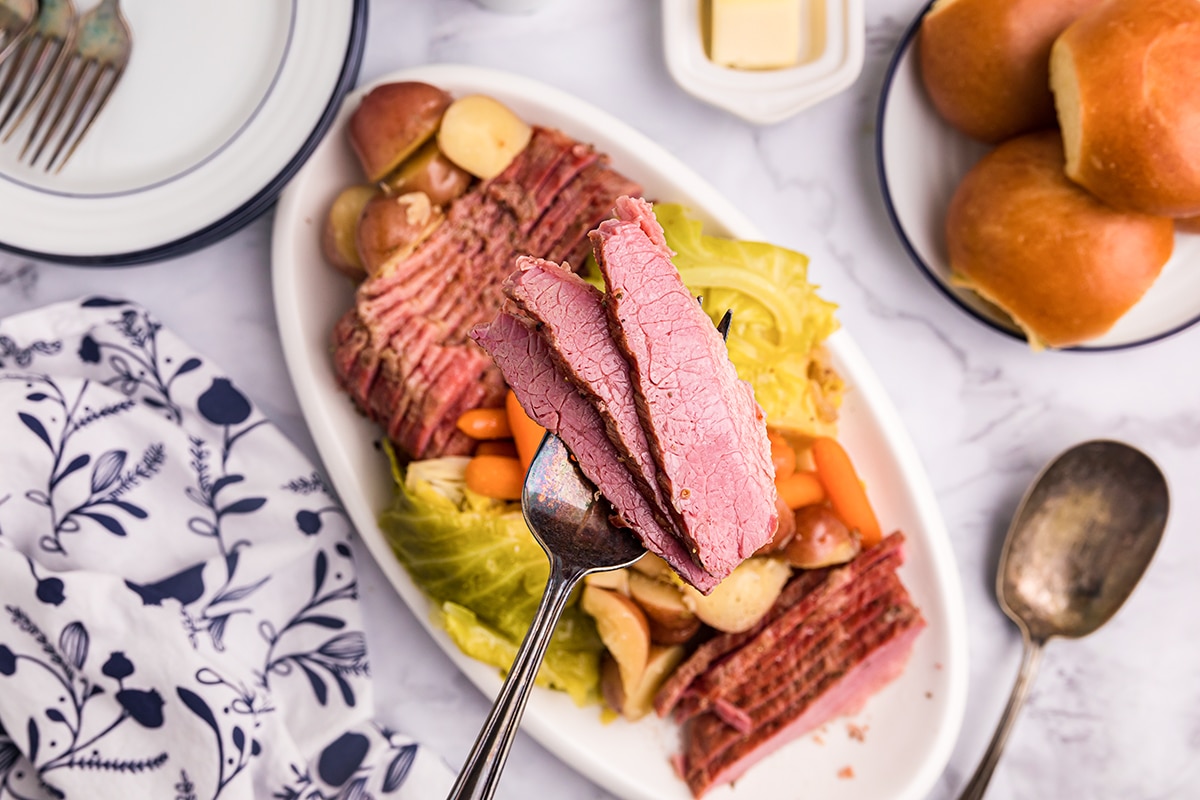 three slices of corned beef on a serving spoon