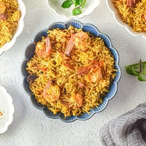 overhead of shrimp biryani in serving bowls