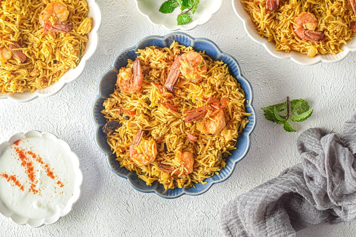 overhead of shrimp biryani in serving bowls