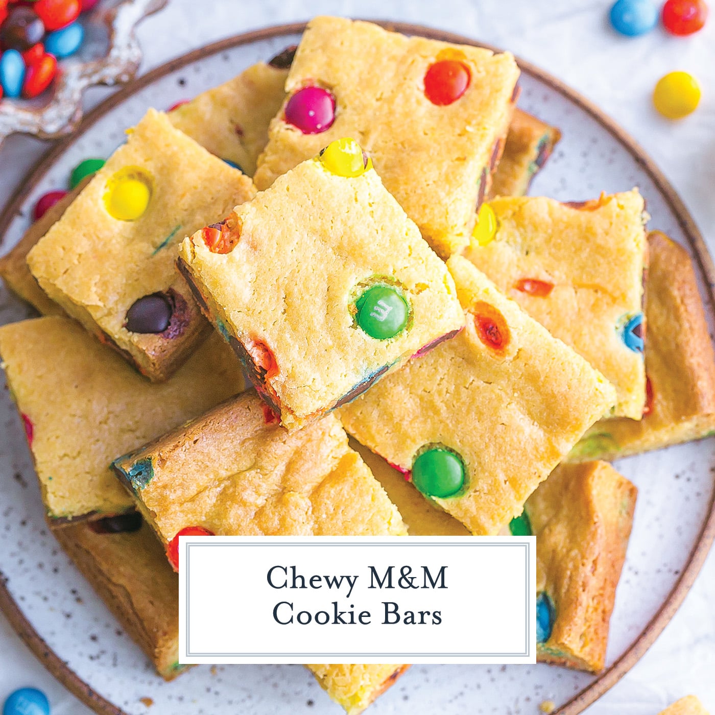 plate of m&m cookie bars with text overlay for facebook