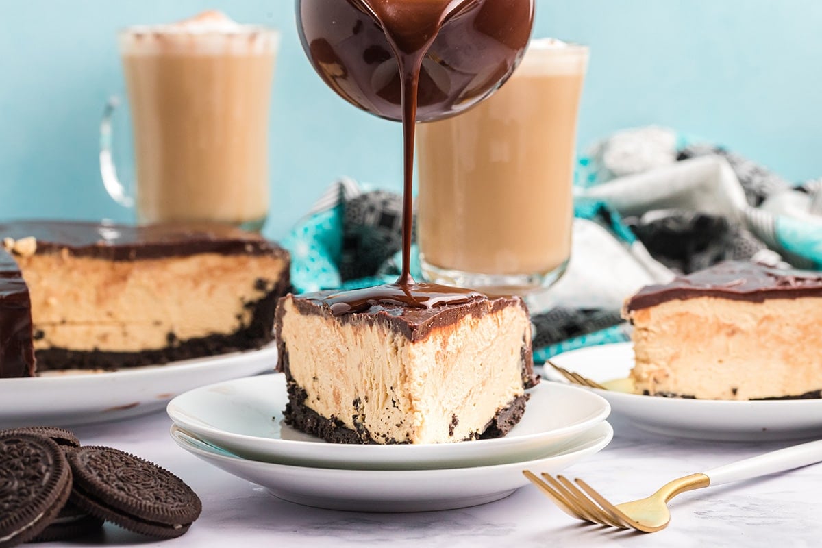 ganache poured onto slice of cheesecake