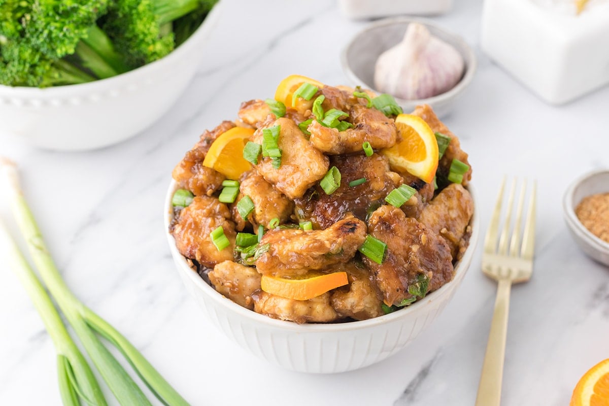 angled shot of bowl of orange chicken