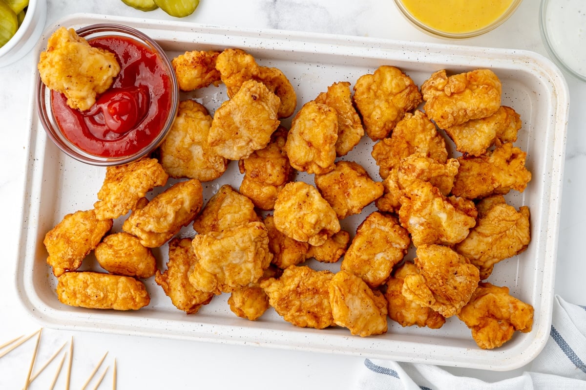 fried chicken pieces on pan with bowl of ketchup