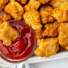 chicken dipped into bowl of ketchup