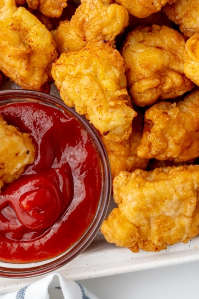 chicken dipped into bowl of ketchup