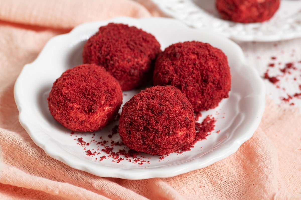 four red velvet cheesecake bites on a plate