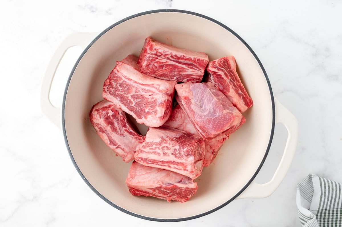 raw short ribs in a dutch oven