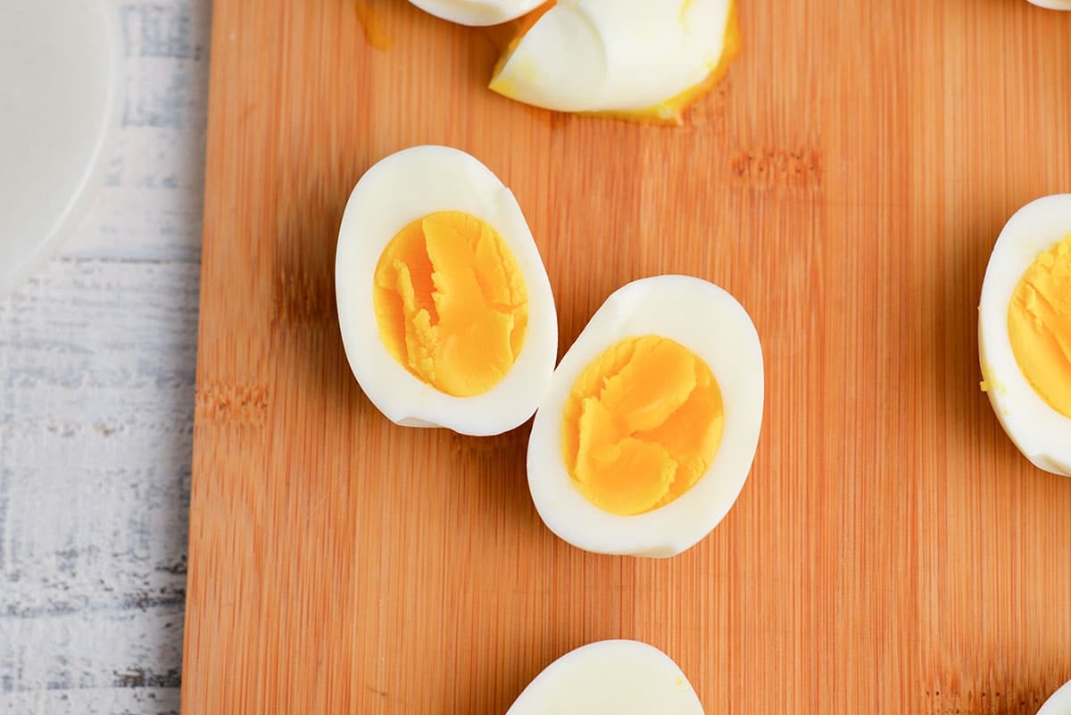 six minute egg cut in half on a wood cutting board