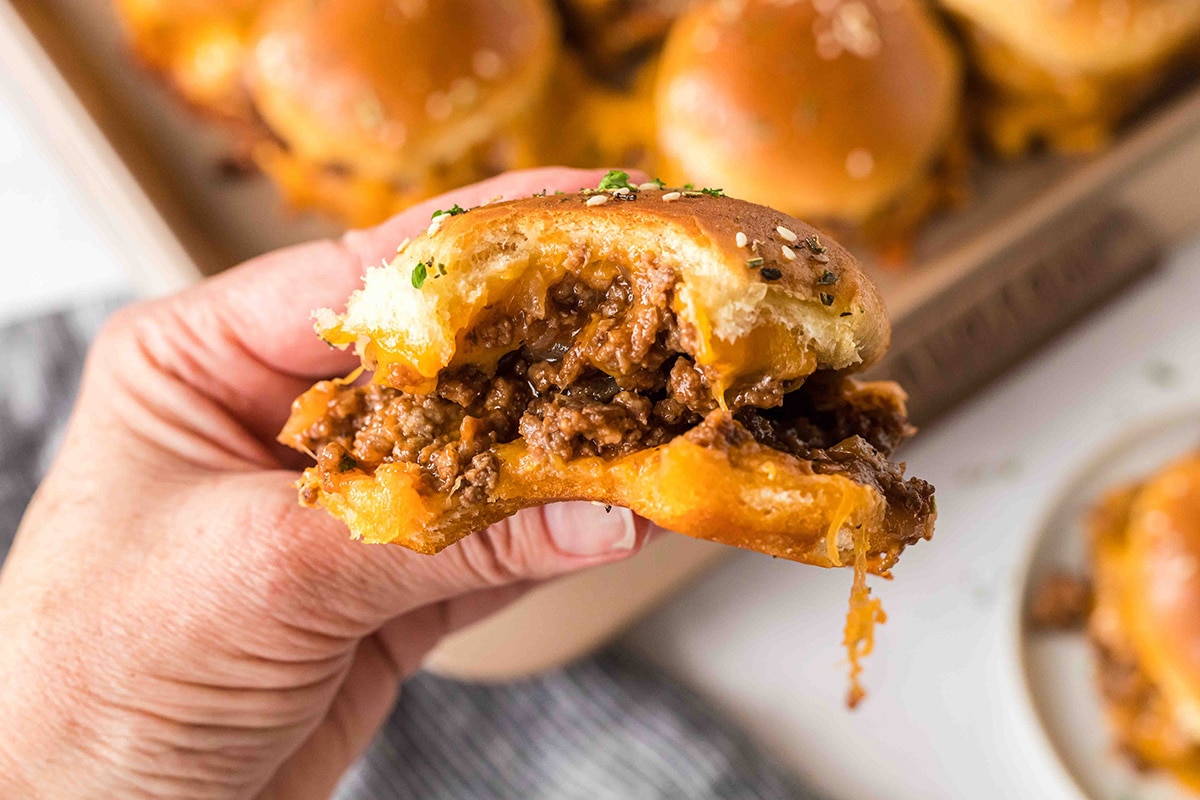 hand holding sloppy joe slider with bite taken out