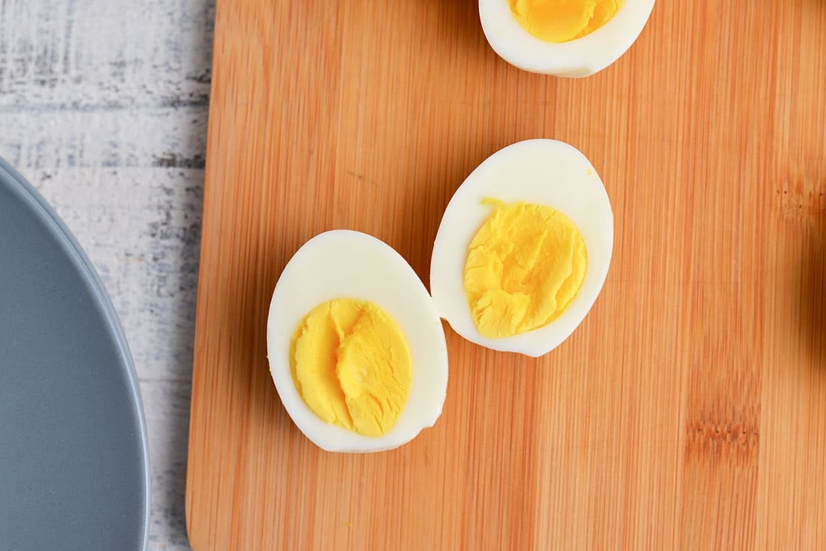 ten minute egg cut in half on a wood cutting board