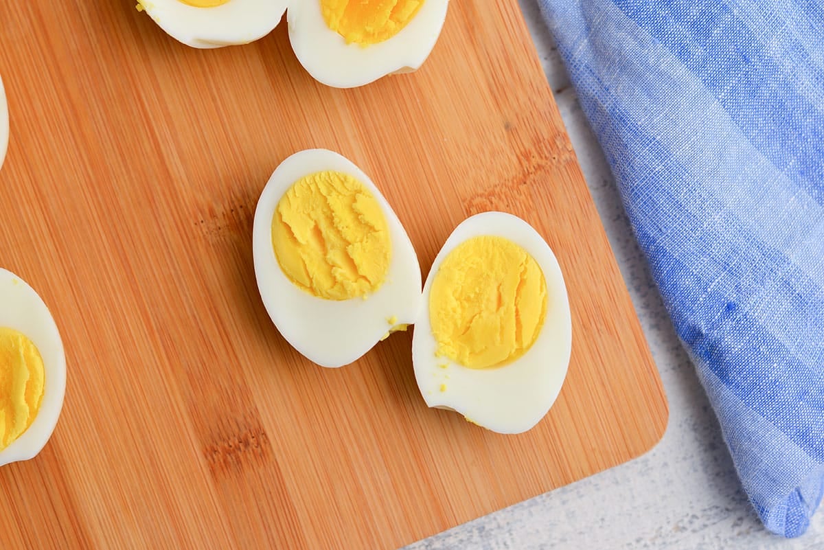 twelve minute egg cut in half on a wood cutting board