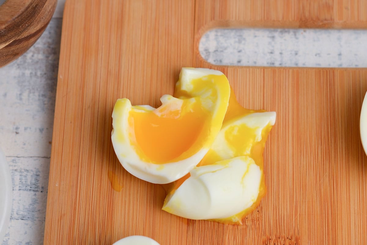 two minute egg cut in half on a wood cutting board