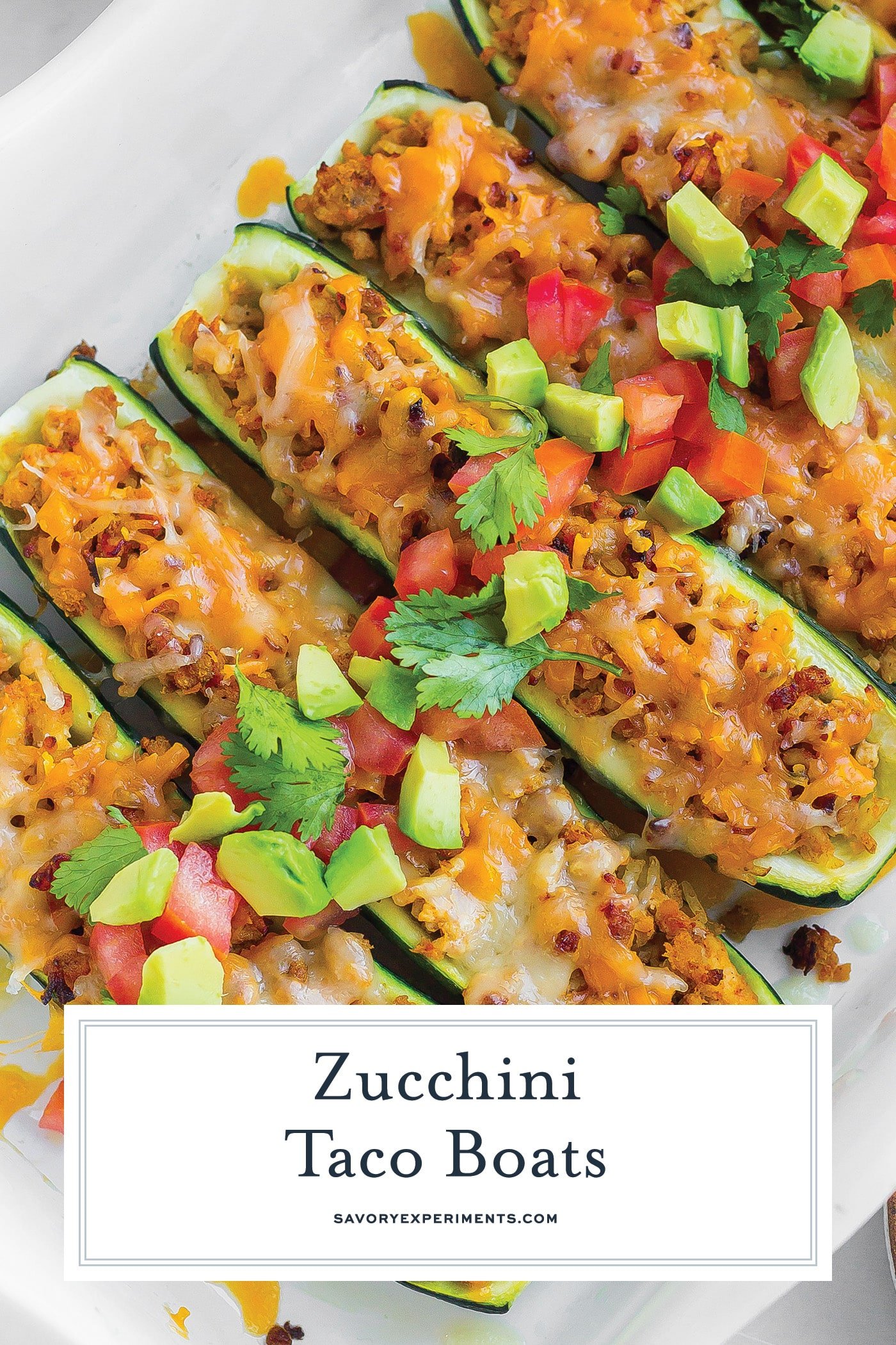 overhead shot of baking dish of zucchini taco boats with text overlay for pinterest