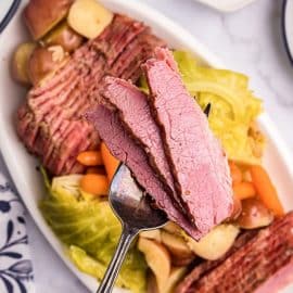 three slices of corned beef on a serving spoon