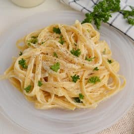 fettuccine alfredo on a glass serving plate