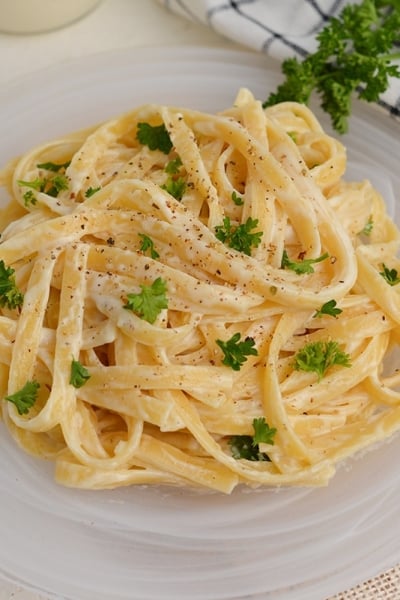 fettuccine alfredo on a glass serving plate