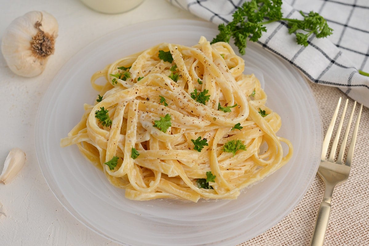 fettuccine alfredo on a glass serving plate