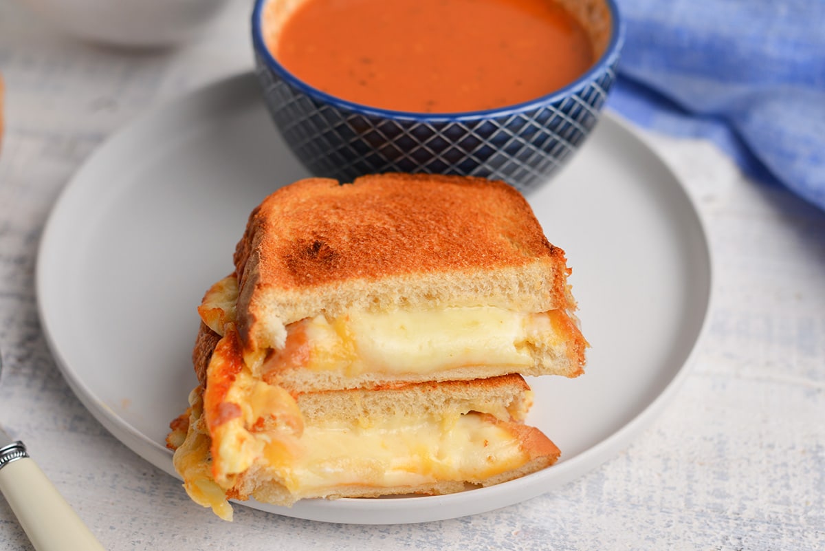 air fryer grilled cheese halves on a plate with tomato soup