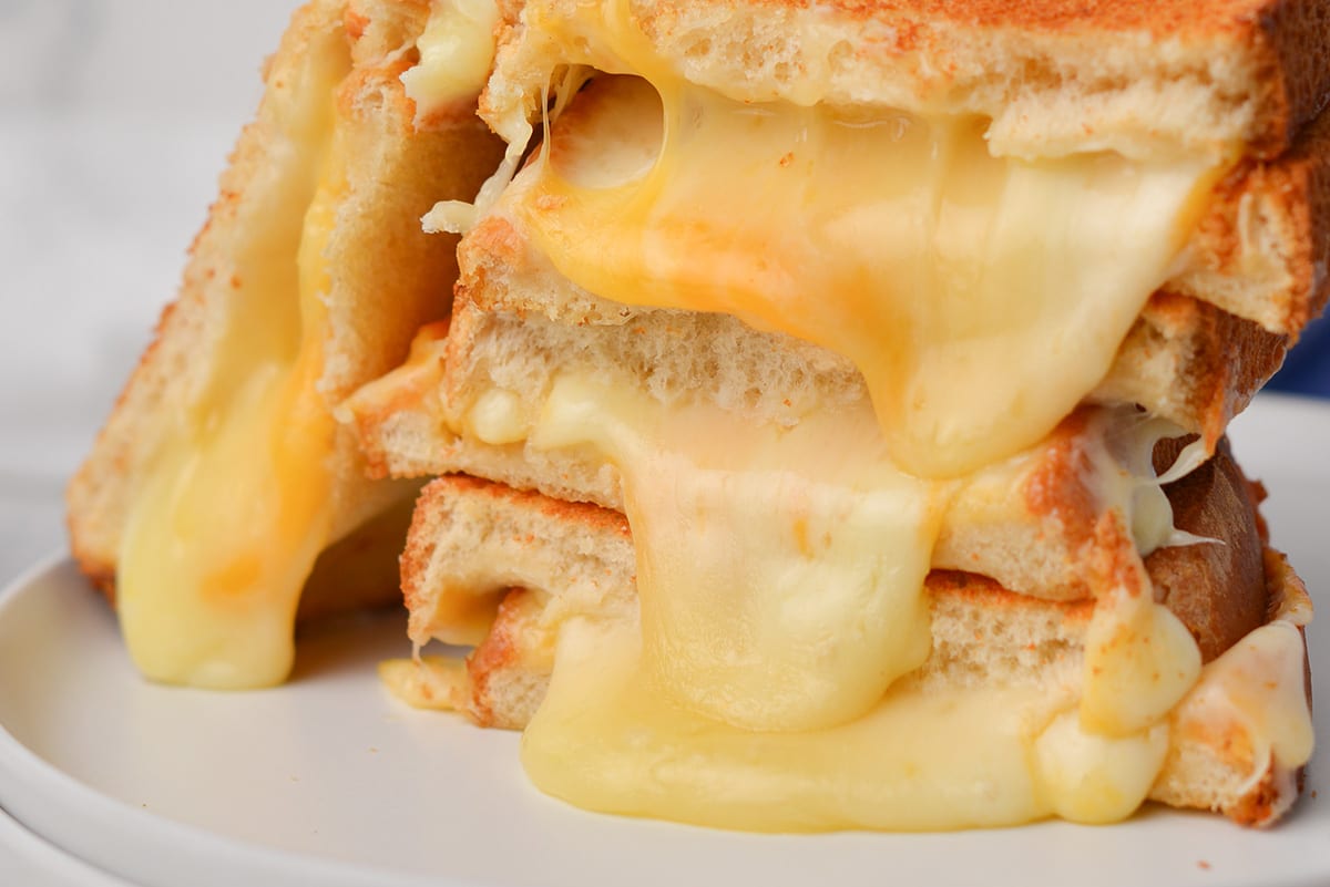 close up of melted cheese coming out of grilled cheese