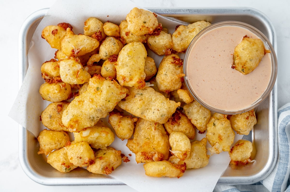 overhead shot of cheese curds with bowl of bloomin onion sauce