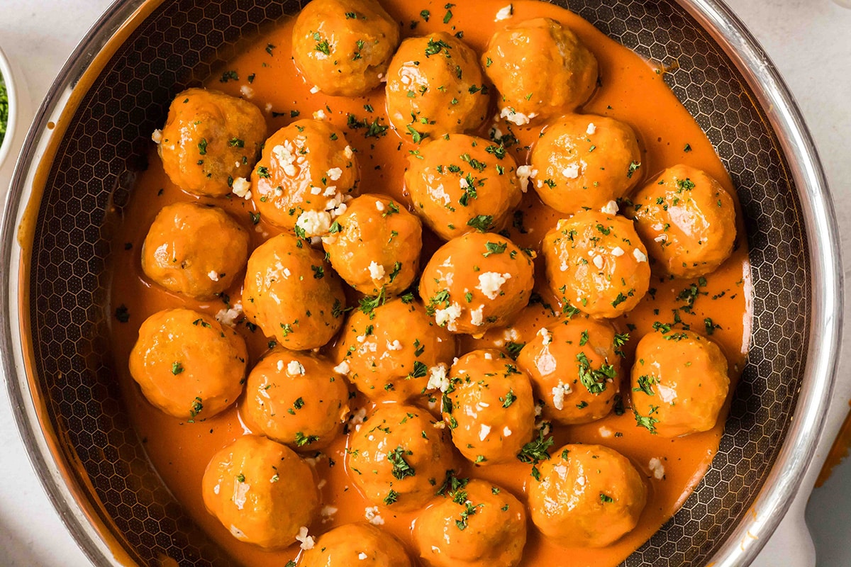 overhead shot of easy buffalo chicken meatballs covered in buffalo sauce in a pan