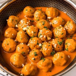 angled shot of buffalo chicken meatballs in a pan