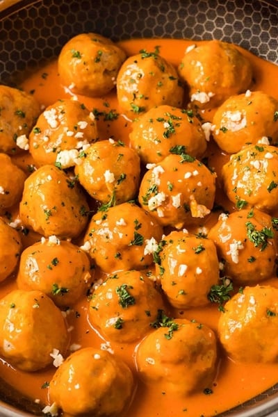 angled shot of buffalo chicken meatballs in a pan