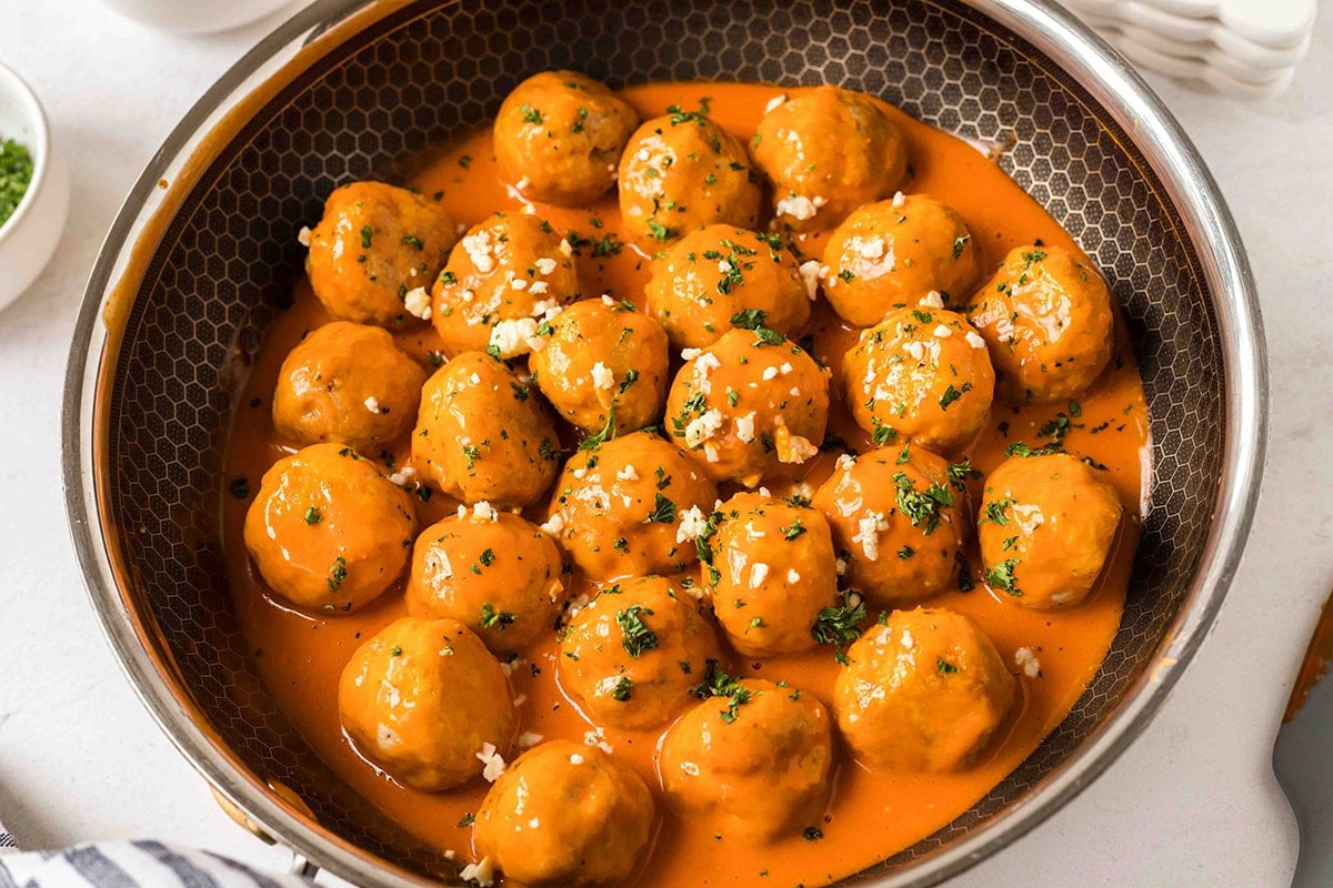 angled shot of buffalo chicken meatballs in a pan