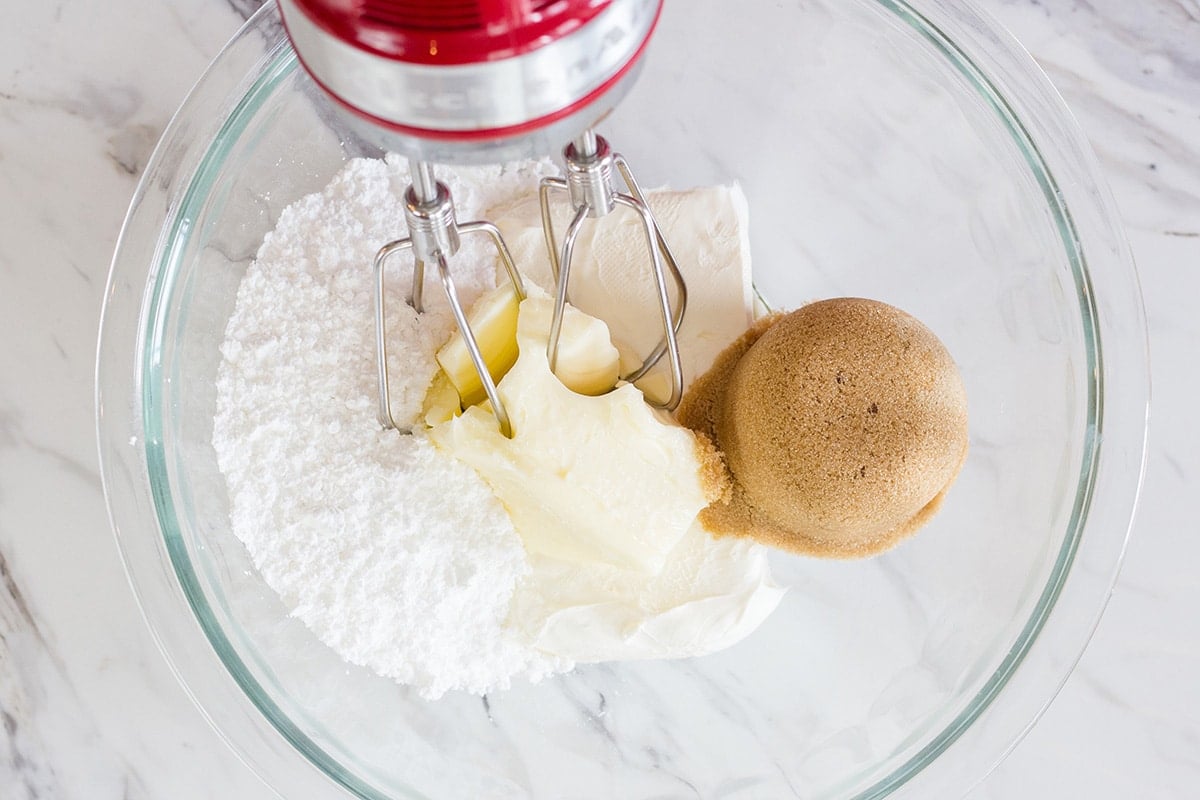 butter, cream cheese, brown sugar and powdered sugar in mixing bowl with mixer