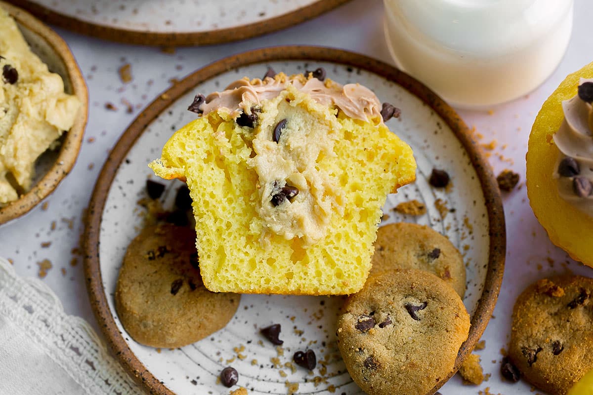 overhead shot of cookie dough cupcake cut in half on a plate