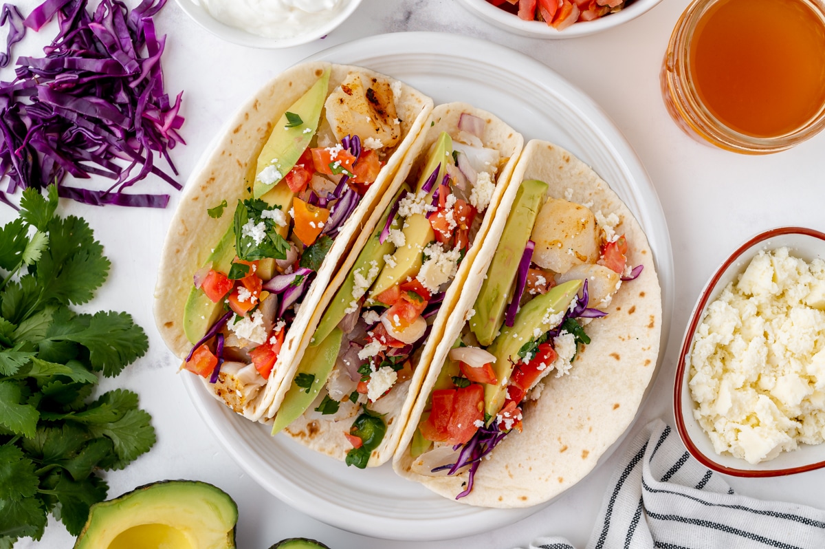 overhead shot of three fish tacos on a plate