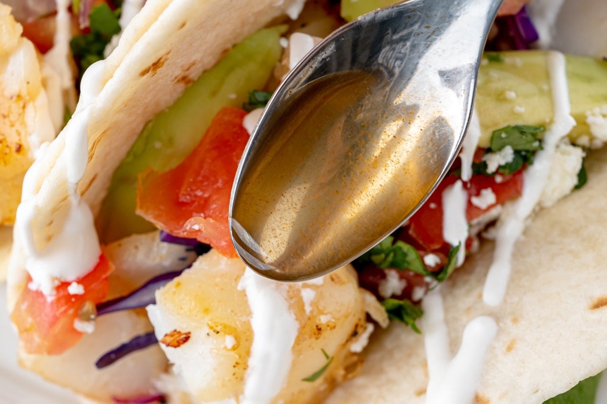 hot sauce spooned onto fish tacos