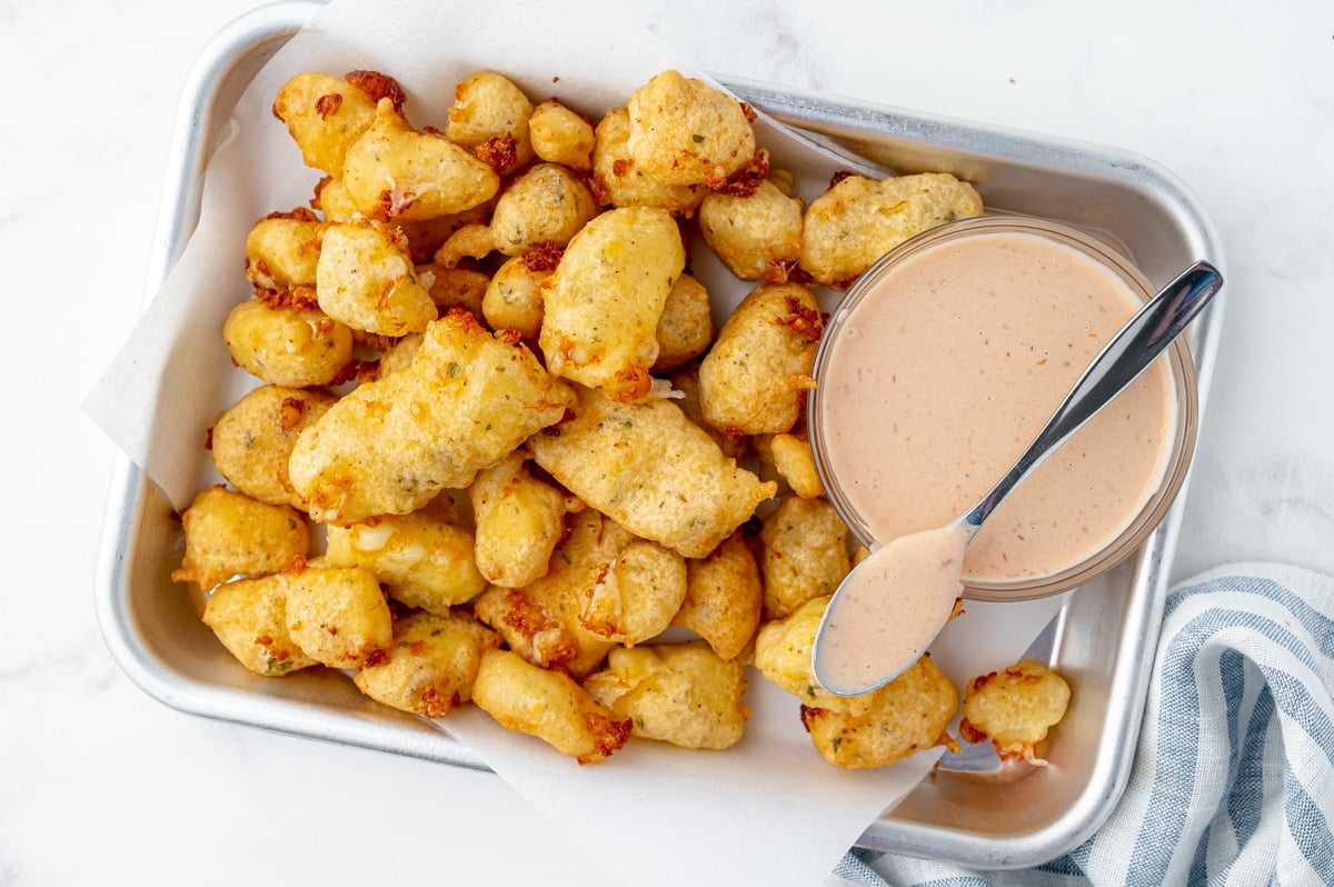 fried cheese curds on tray with bowl of dipping sauce
