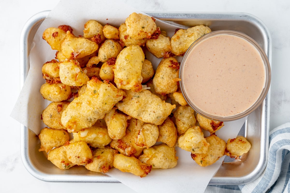 overhead shot of cheese curds on tray with dipping sauce