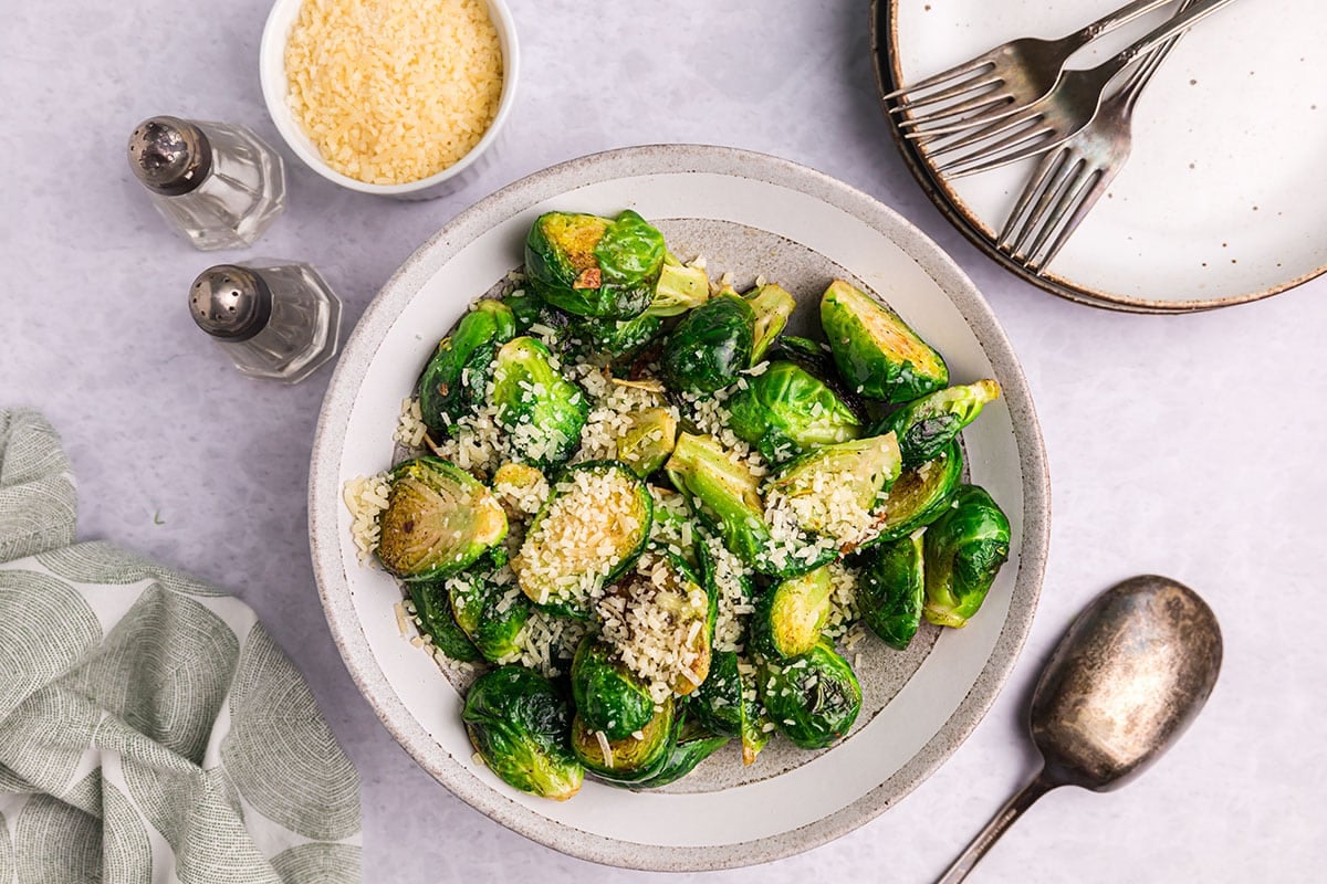 garlic butter brussels sprouts in bowl topped with cheese