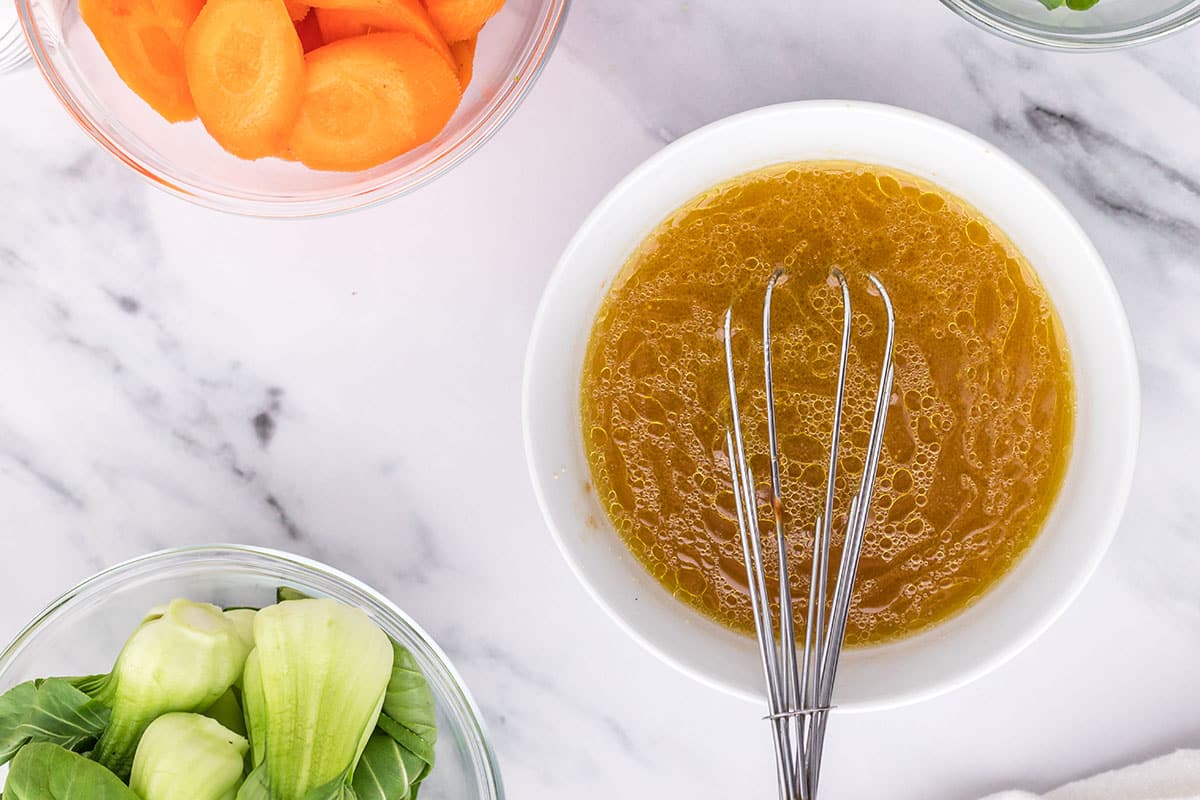 chicken marinade in a bowl with a whisk