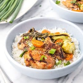 close up angled shot of honey garlic chicken in a bowl with rice