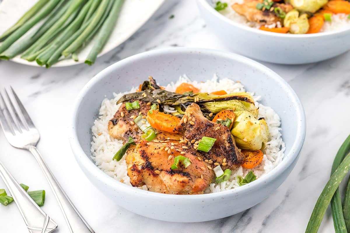 close up angled shot of honey garlic chicken in a bowl with rice