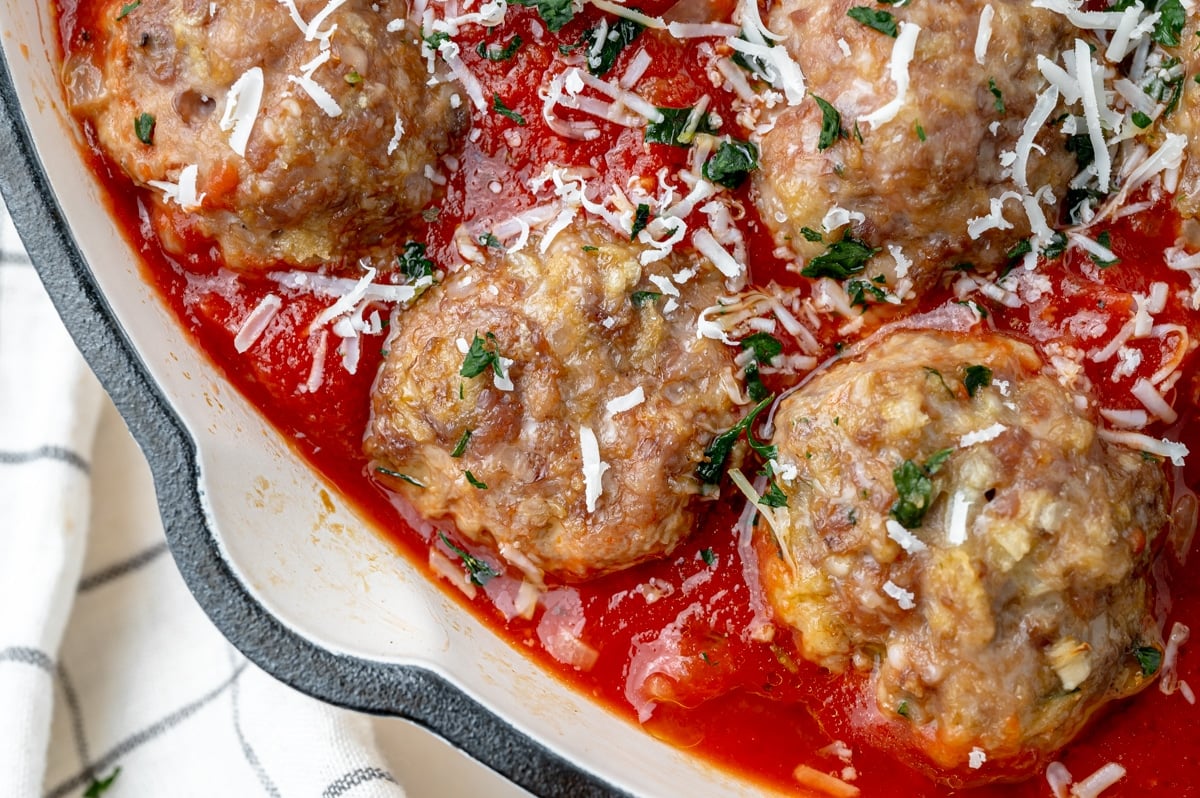 close up of cooked meatball in red sauce