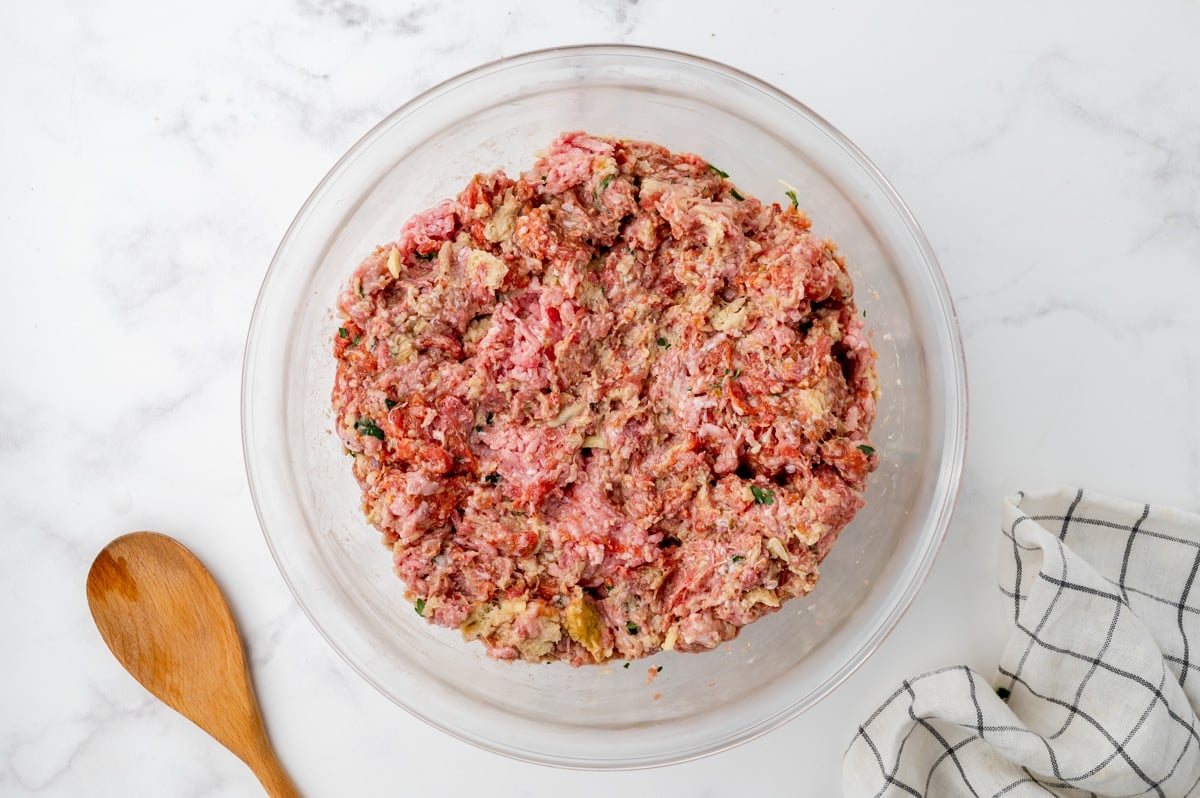 meatball mixture in glass mixing bowl