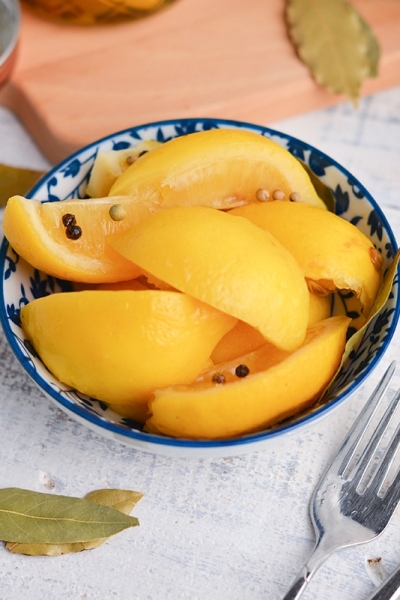 angled shot of preserved lemons in a blue bowl